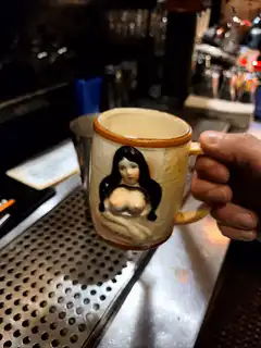 Hand holding a mug with a pin-up girl