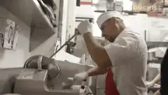Chef sharpening a knife with a machine