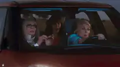 Three women in a car looking shocked