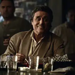 Tony Soprano smiling at the table
