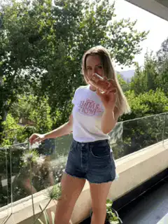 woman holding up a small glass