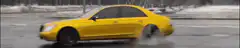 Yellow car drifting on wet road