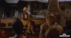 woman in yellow hat smiling at bar