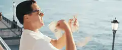 Man throwing money into the ocean
