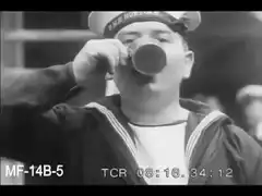 Sailor drinks from cup and smiles