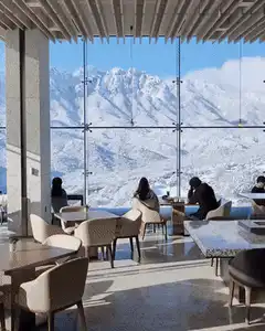 People in cafe with snowy mountain view