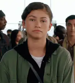 Zendaya smirking in a crowd