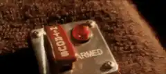 Finger presses red button on armed switch