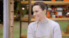 Daisy Ridley laughing and rolling up sleeves