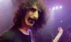 Frank Zappa playing guitar on stage