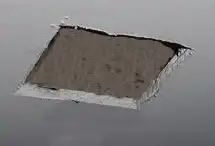 Cat peeks through hole in ceiling