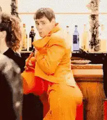 Man in orange suit wiggling his butt