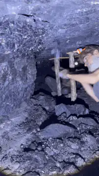 Man mining coal in a dark cave