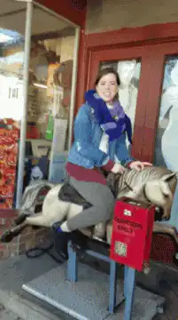 Woman dancing on a coin-operated horse