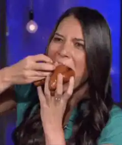 Woman eating a large sausage