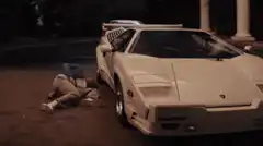 Man opens car door while lying on ground