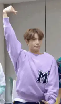 Man in purple sweatshirt waving hand