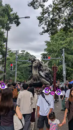 Crowd watching giant monster statue