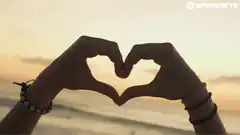 hands making heart shape at sunset