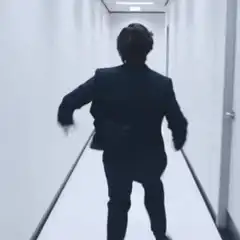 Man in suit running down hallway