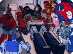 Megatron lying on a table surrounded by Autobots