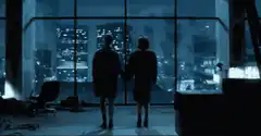 Couple holding hands looking at city skyline