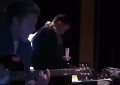 Man playing guitar and singing on stage