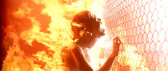 woman on fire touching chain link fence