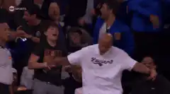 Bald man in Xavier shirt dancing at basketball game