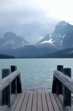 wooden dock over lake with mountains
