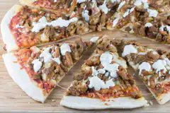 sliced pizza with meat and white sauce