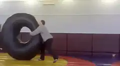 Man rolls tire through kids