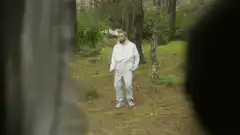 Man in white tracksuit in forest