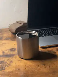 coffee cup on desk next to laptop