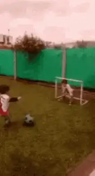 kid kicks soccer ball into goal
