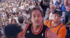 Man in Suns jersey reacting with shock