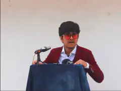 Man in red jacket and sunglasses spreads arms
