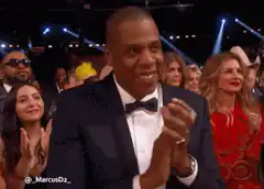 Jay-Z clapping and smiling at an awards show