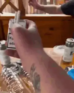 Cat drinks from cigarette pack