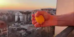 Hand squeezing a lemon on a balcony