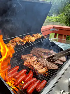 Grilling steak, sausages, and chicken on a barbecue