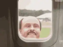 Man smiling out of airplane window