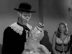 Man in mask tips hat to mannequin