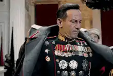 General putting on jacket
