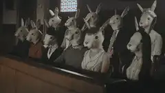 people in rabbit masks sitting in a row