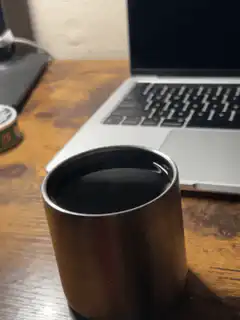 Coffee cup on desk next to laptop