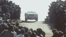 Lancia rally car racing past crowd