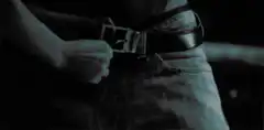 person unbuckling belt
