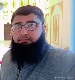 Man with beard and glasses looking at camera