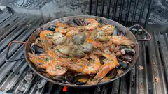 Seafood paella cooking on a grill